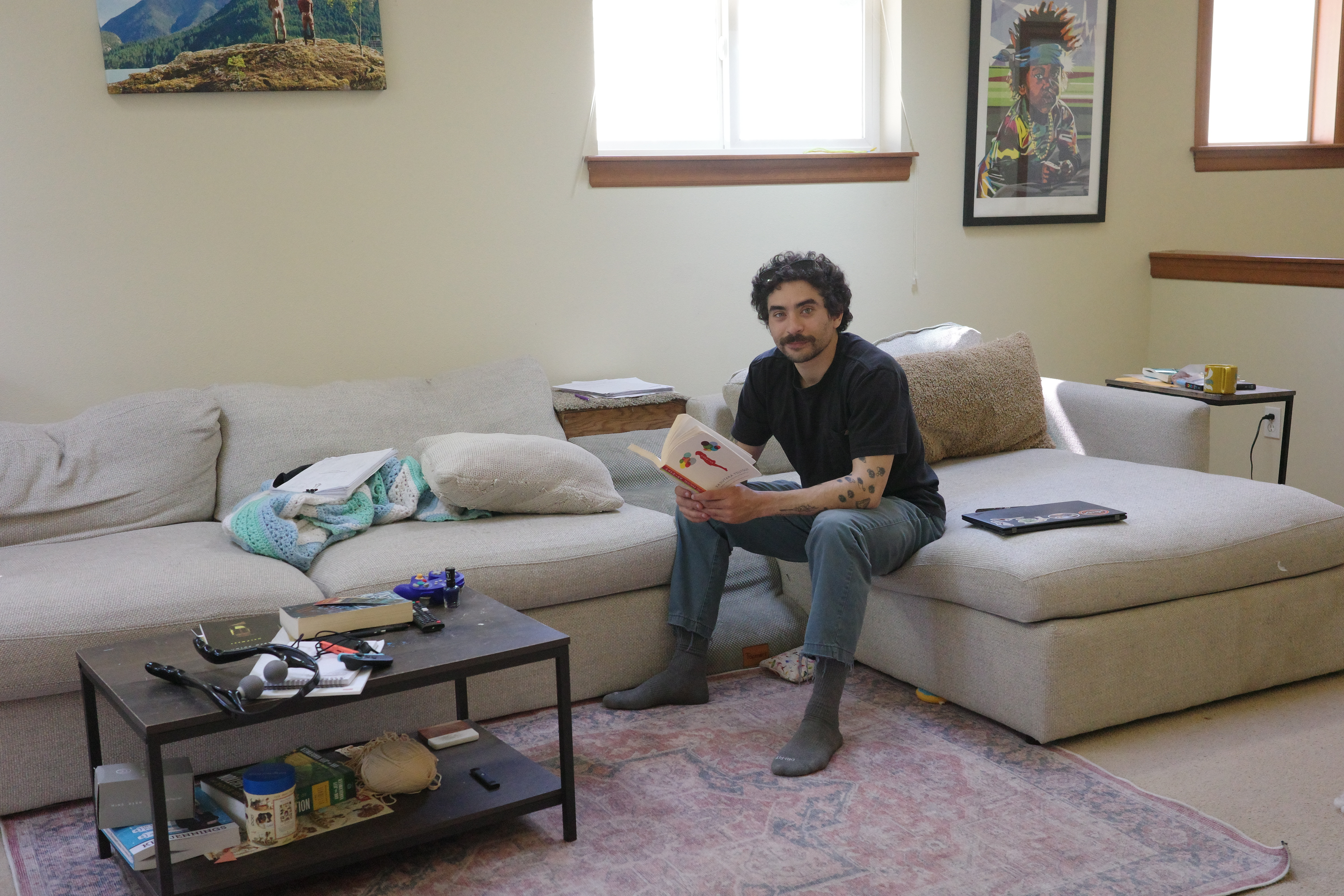 A man reading a book, aware his photograph is being taken